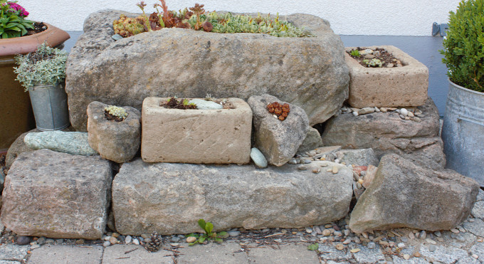 Steinegarten mit Pflanztrögen vorm&nbsp;Haus